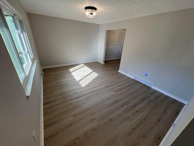 5464 Aspen Rd, Columbus, OH 43229 - unfurnished room with wood finished floors, baseboards, and a textured ceiling