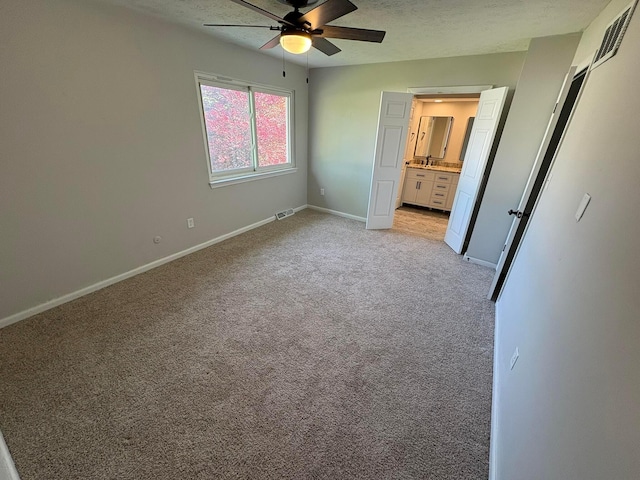 5464 Aspen Rd, Columbus, OH 43229 - unfurnished bedroom featuring light carpet, baseboards, ensuite bathroom, a textured ceiling, and a ceiling fan