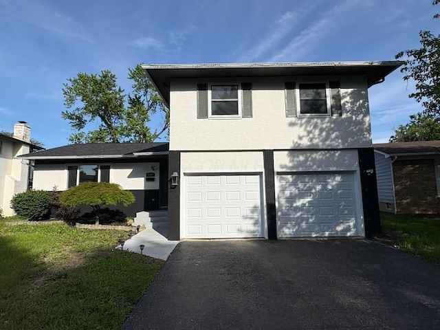 5464 Aspen Rd, Columbus, OH 43229 - view of front of property with asphalt driveway, an attached garage, and stucco siding