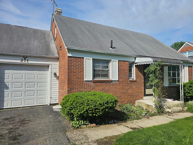 271 Carilla Ln, Columbus, OH 43228 - view of front of home featuring brick siding, an attached garage, a chimney, and driveway