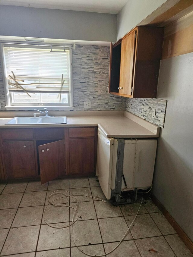 271 Carilla Ln, Columbus, OH 43228 - kitchen featuring a sink, light countertops, dishwasher, decorative backsplash, and light tile patterned floors