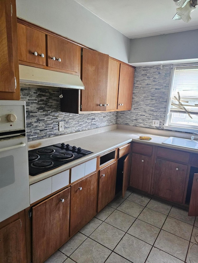 271 Carilla Ln, Columbus, OH 43228 - kitchen with white oven, black electric cooktop, under cabinet range hood, a sink, and light countertops