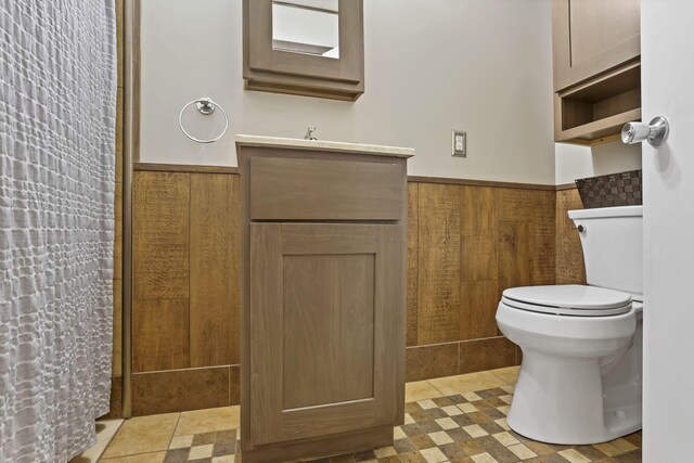 14609 Hock Hocking Rd, Logan, OH 43138 - bathroom with wainscoting, vanity, toilet, and curtained shower