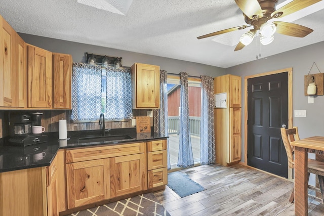 14609 Hock Hocking Rd, Logan, OH 43138 - kitchen featuring a sink, wood finished floors, a ceiling fan, dark countertops, and a textured ceiling