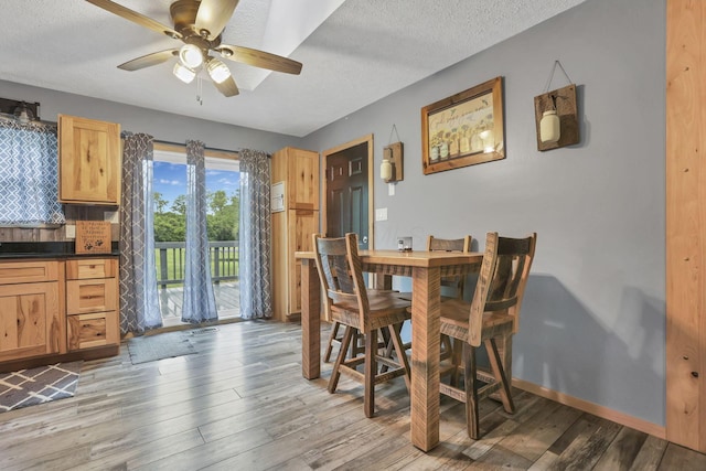 14609 Hock Hocking Rd, Logan, OH 43138 - dining space with ceiling fan, light wood-style floors, a textured ceiling, and baseboards