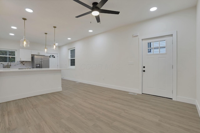 1676 Parsons Ave, Columbus, OH 43207 - kitchen featuring stainless steel fridge with ice dispenser, recessed lighting, light countertops, white cabinets, and light wood-style floors