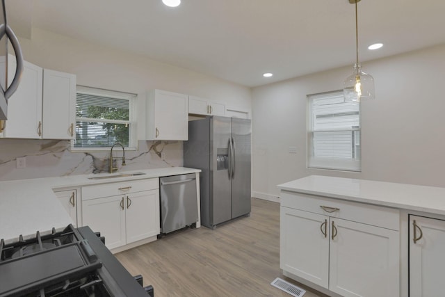 1676 Parsons Ave, Columbus, OH 43207 - kitchen with stainless steel appliances, a sink, light countertops, white cabinetry, and recessed lighting