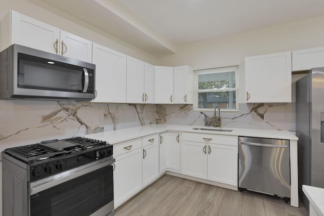 1676 Parsons Ave, Columbus, OH 43207 - kitchen with stainless steel appliances, a sink, light countertops, and white cabinetry