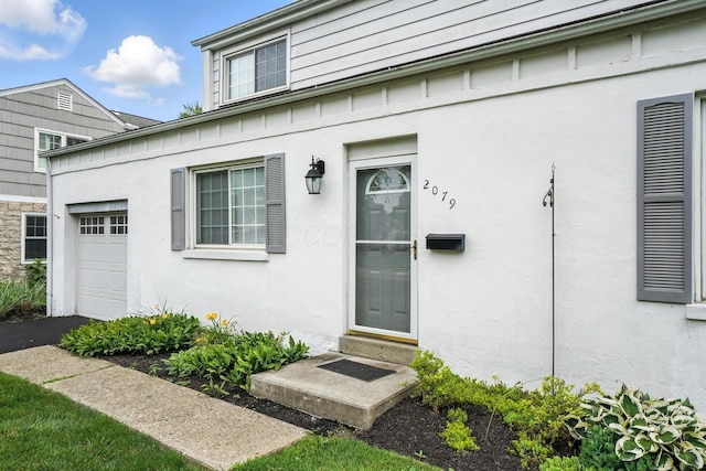2079 Inchcliff Rd, Upper Arlington, OH 43221 - view of exterior entry featuring a garage and stucco siding