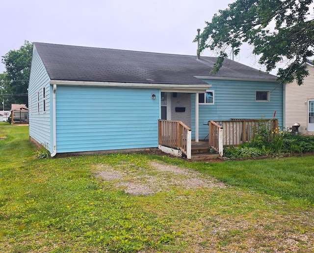 405 E 5th St, West Lafayette, OH 43845 - back of house featuring a lawn, a wooden deck, and roof with shingles