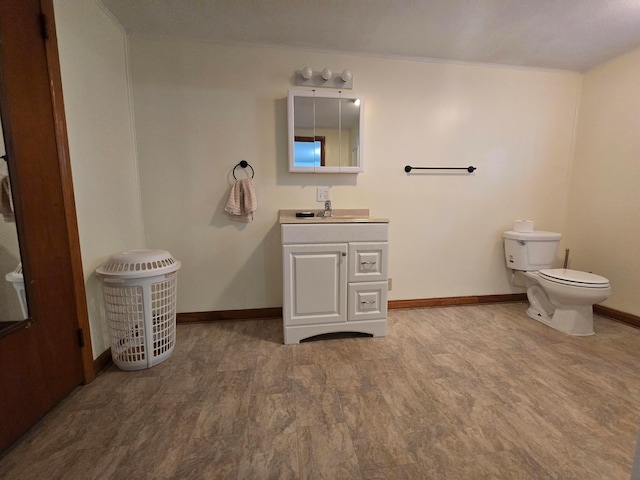 405 E 5th St, West Lafayette, OH 43845 - bathroom with vanity, baseboards, toilet, and wood finished floors