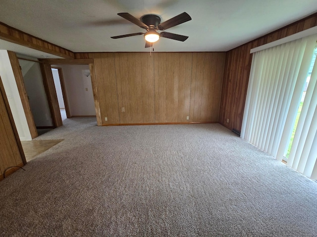 405 E 5th St, West Lafayette, OH 43845 - empty room featuring light carpet, ceiling fan, wood walls, and baseboards