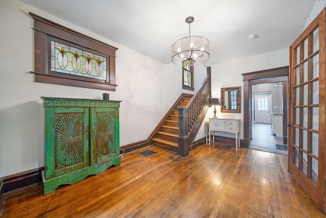 663 Wilson Ave, Columbus, OH 43205 - stairs with wood-type flooring, a chandelier, and baseboards