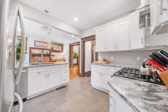 663 Wilson Ave, Columbus, OH 43205 - kitchen featuring freestanding refrigerator, a sink, white cabinets, recessed lighting, and hanging light fixtures