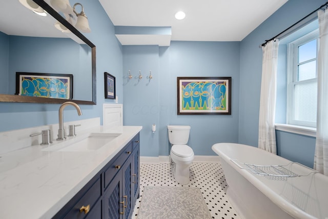 663 Wilson Ave, Columbus, OH 43205 - bathroom with baseboards, vanity, a freestanding bath, and toilet