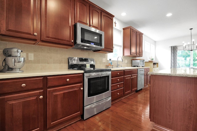 7313 Bromfield Dr, Canal Winchester, OH 43110 - kitchen featuring appliances with stainless steel finishes, dark wood-style flooring, tasteful backsplash, a chandelier, and recessed lighting