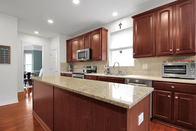 7313 Bromfield Dr, Canal Winchester, OH 43110 - kitchen featuring stainless steel appliances, a sink, decorative backsplash, dark wood-type flooring, and recessed lighting