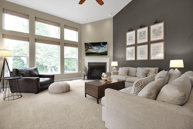 7313 Bromfield Dr, Canal Winchester, OH 43110 - carpeted living area with ceiling fan, a high ceiling, a fireplace with flush hearth, and baseboards