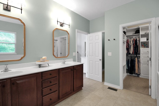 7313 Bromfield Dr, Canal Winchester, OH 43110 - full bathroom featuring double vanity, tile patterned flooring, and a walk in closet