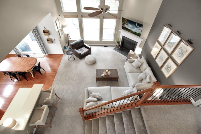 7313 Bromfield Dr, Canal Winchester, OH 43110 - living area with wood finished floors, ceiling fan, a fireplace with flush hearth, baseboards, and a towering ceiling