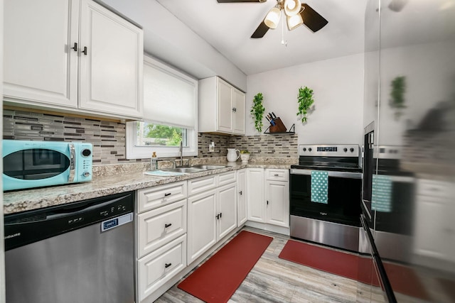 4351 Broadhurst Dr, Columbus, OH 43213 - kitchen featuring appliances with stainless steel finishes, a sink, decorative backsplash, white cabinets, and light wood finished floors