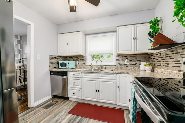 4351 Broadhurst Dr, Columbus, OH 43213 - kitchen with stainless steel appliances, a sink, decorative backsplash, and light wood-style floors