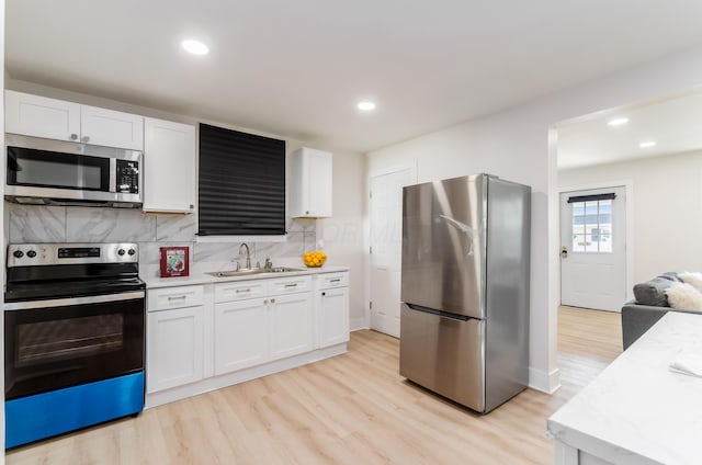 143 S Princeton Ave, Columbus, OH 43222 - kitchen with appliances with stainless steel finishes, a sink, light countertops, light wood-style floors, and white cabinets