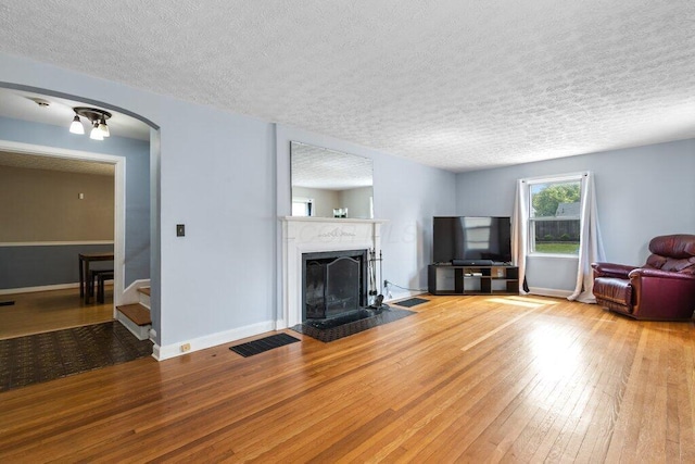 644 Eastmoor Blvd, Columbus, OH 43209 - living area featuring a textured ceiling, stairs, wood-type flooring, a fireplace with flush hearth, and baseboards