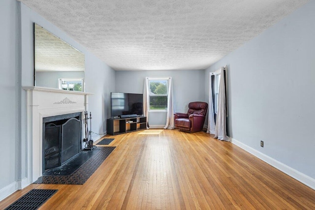 644 Eastmoor Blvd, Columbus, OH 43209 - living room with wood-type flooring, a fireplace with flush hearth, baseboards, and a textured ceiling
