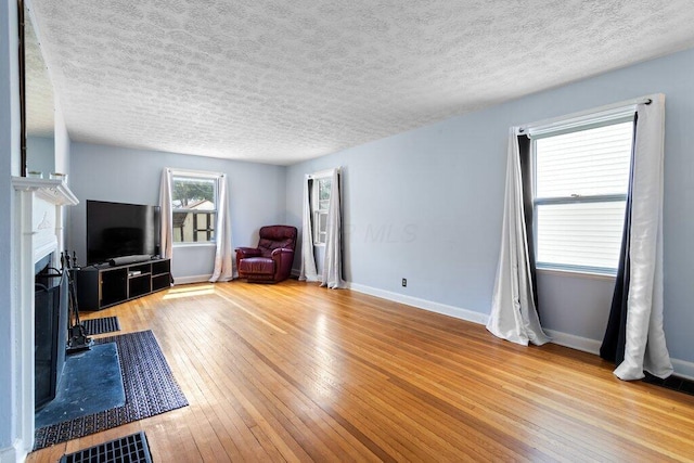 644 Eastmoor Blvd, Columbus, OH 43209 - living area featuring a textured ceiling, hardwood / wood-style floors, baseboards, and a fireplace