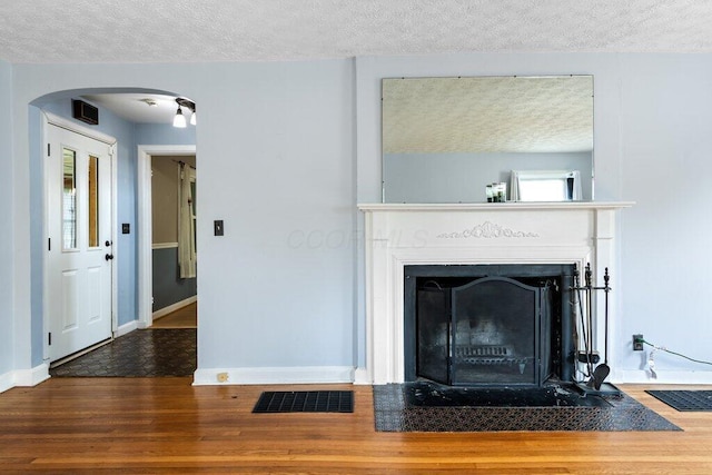 644 Eastmoor Blvd, Columbus, OH 43209 - detailed view of a textured ceiling, wood finished floors, arched walkways, a fireplace with flush hearth, and baseboards