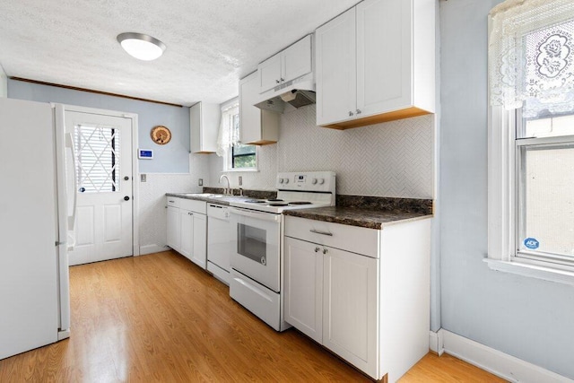 644 Eastmoor Blvd, Columbus, OH 43209 - kitchen with white appliances, under cabinet range hood, a sink, dark countertops, and light wood-style flooring
