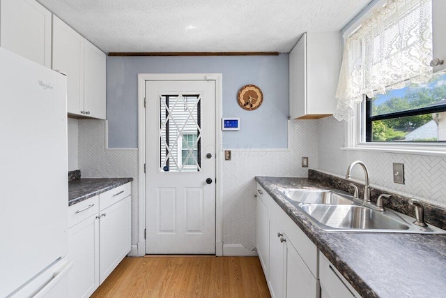 644 Eastmoor Blvd, Columbus, OH 43209 - kitchen featuring freestanding refrigerator, a sink, white cabinetry, light wood finished floors, and dark countertops