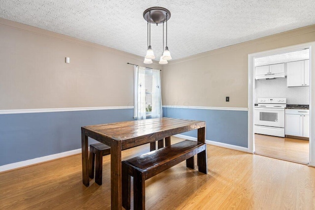 644 Eastmoor Blvd, Columbus, OH 43209 - dining space featuring light wood finished floors, baseboards, a textured ceiling, and ornamental molding