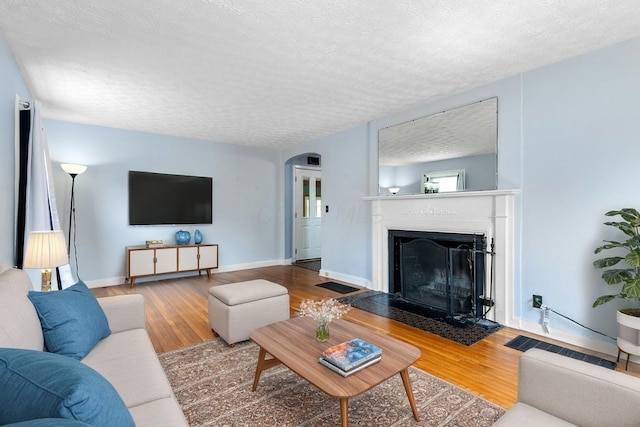 644 Eastmoor Blvd, Columbus, OH 43209 - living area featuring arched walkways, wood finished floors, a fireplace with flush hearth, and a textured ceiling