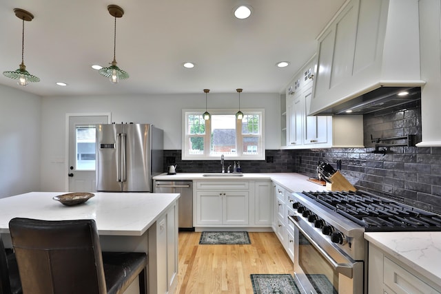 2009 Zollinger Rd, Columbus, OH 43221 - kitchen featuring stainless steel appliances, a sink, premium range hood, backsplash, and light stone countertops