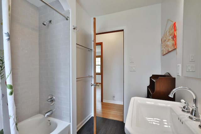 2009 Zollinger Rd, Columbus, OH 43221 - bathroom with a sink, shower / bath combination with curtain, wood finished floors, and baseboards