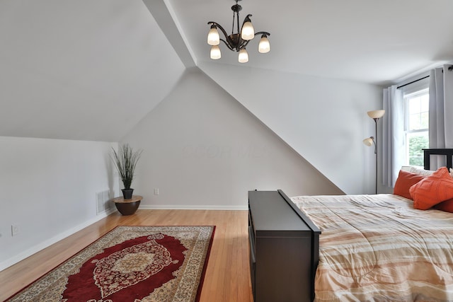 2009 Zollinger Rd, Columbus, OH 43221 - bedroom featuring wood finished floors, a chandelier, vaulted ceiling, and baseboards