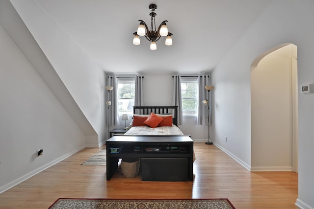 2009 Zollinger Rd, Columbus, OH 43221 - bedroom featuring light wood-style flooring, arched walkways, a chandelier, and baseboards
