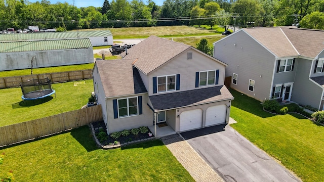 1627 Metcalfe Ave, Columbus, OH 43207 - view of front of house with asphalt driveway, a trampoline, an attached garage, and roof with shingles