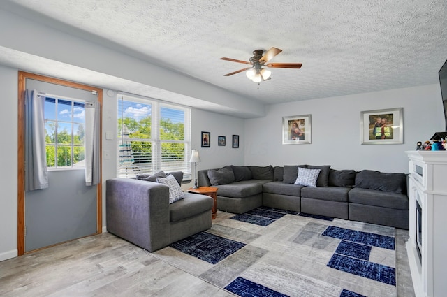 1627 Metcalfe Ave, Columbus, OH 43207 - living room with light wood finished floors, ceiling fan, plenty of natural light, and a textured ceiling