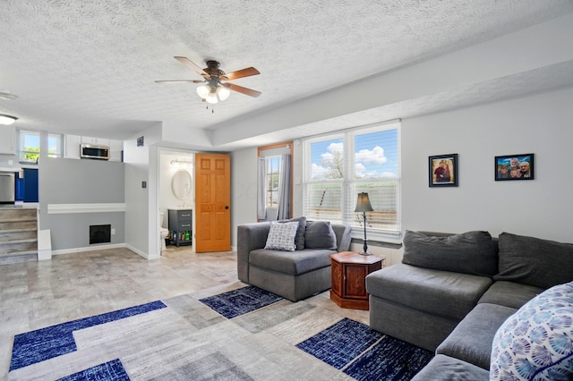 1627 Metcalfe Ave, Columbus, OH 43207 - living area featuring a ceiling fan, a textured ceiling, baseboards, and light wood-style flooring