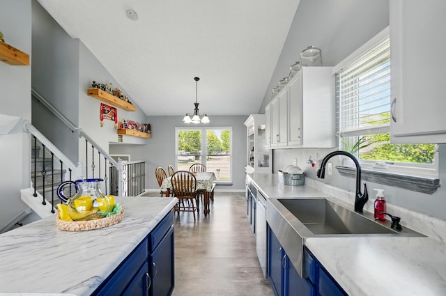 1627 Metcalfe Ave, Columbus, OH 43207 - kitchen with blue cabinetry, vaulted ceiling, a chandelier, a sink, and dishwashing machine