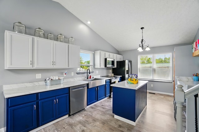 1627 Metcalfe Ave, Columbus, OH 43207 - kitchen featuring appliances with stainless steel finishes, blue cabinets, a center island, light wood finished floors, and a sink