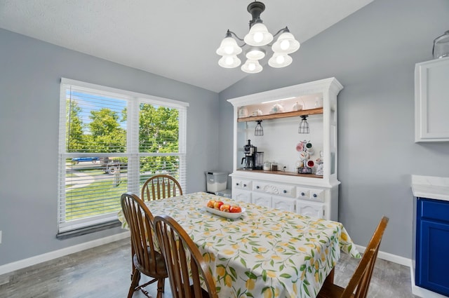 1627 Metcalfe Ave, Columbus, OH 43207 - dining room featuring a chandelier, wood finished floors, lofted ceiling, and baseboards