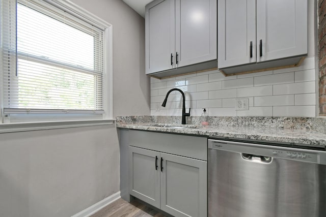 2567 Joyce Ave, Columbus, OH 43211 - kitchen featuring stainless steel dishwasher, a sink, tasteful backsplash, and wood finished floors