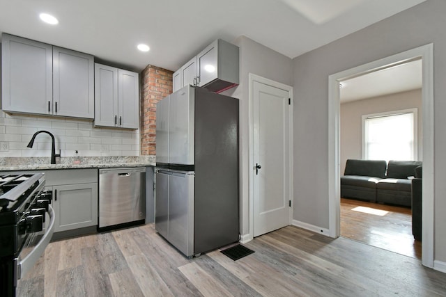 2567 Joyce Ave, Columbus, OH 43211 - kitchen featuring stainless steel appliances, gray cabinetry, light wood finished floors, and recessed lighting