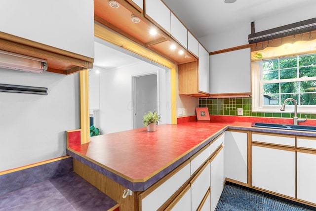 1631 Roxbury Rd Unit D2, Columbus, OH 43212 - kitchen featuring white cabinets, tasteful backsplash, and a peninsula