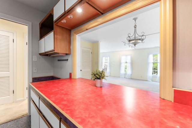 1631 Roxbury Rd Unit D2, Columbus, OH 43212 - kitchen featuring carpet floors, a chandelier, hanging light fixtures, and white cabinetry
