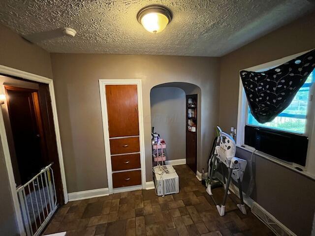 1231 E 23rd Ave, Columbus, OH 43211 - laundry area featuring arched walkways, a textured ceiling, and baseboards